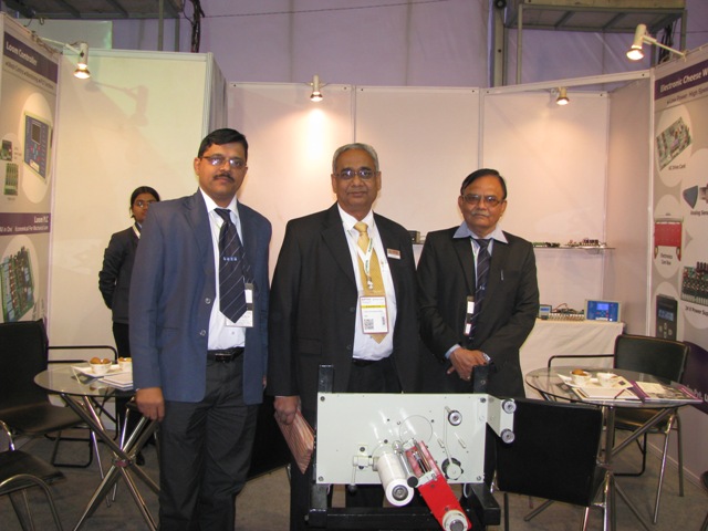 Beta Computronics team with a machine at an industry exhibition stand